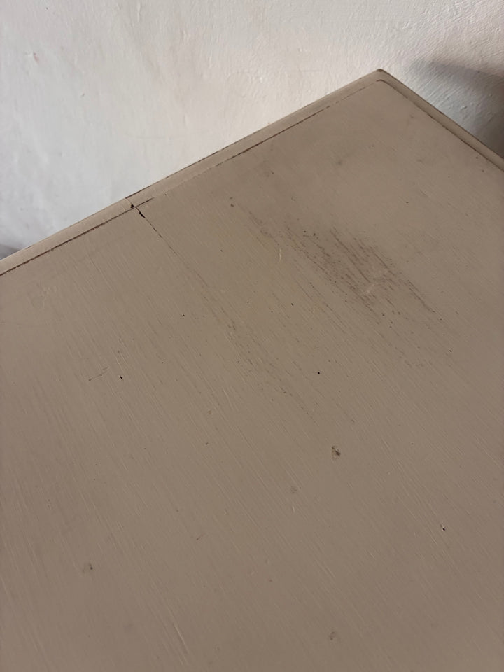 Close-up of the top surface of a vintage painted side table showing aged finish and subtle wear marks.