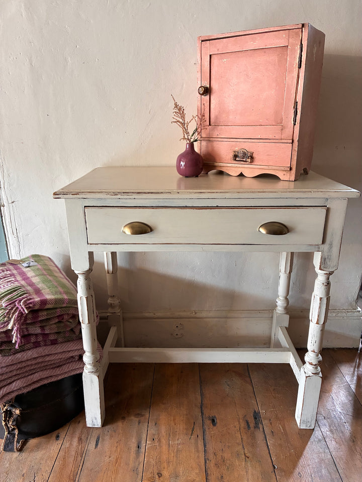 Vintage painted side table with drawer and brass handle, featuring off-white finish and charming distressing from Source for the Goose, Devon.