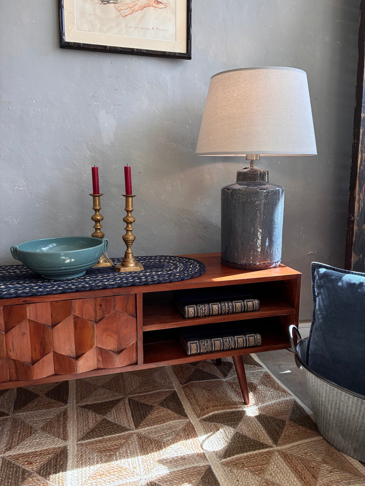 Retro Swoon Editions TV Stand with tactile wood tiles, lamp, candles, and decor creating a stylish living space.