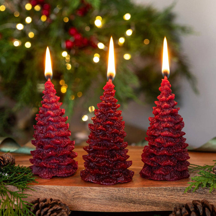 Pintail Candles - Christmas Spice Christmas Tree Candle trio burning in burgundy, creating festive scents.