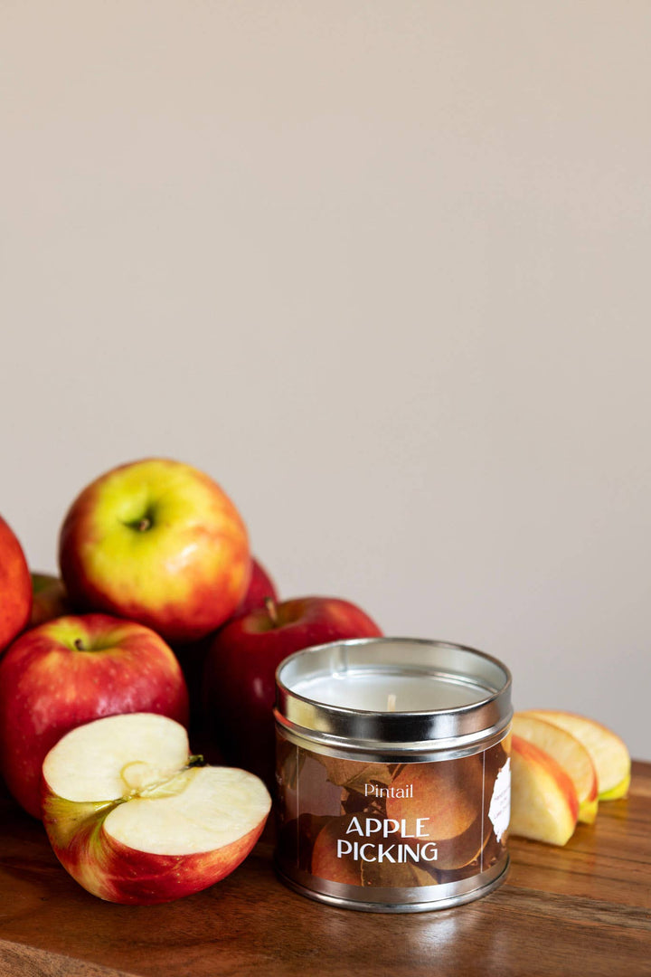 Pintail Candles Apple Picking Classic Tin Candles | Candle in a Tin with fresh apples on a wooden table.