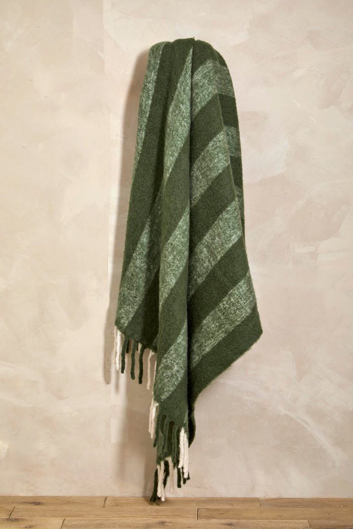 Wool Blend Fern Green Wide Stripe Throw hanging with chunky tassels and textured style for cozy decor.