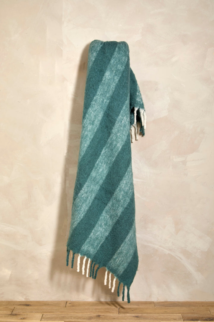 Wool Blend Glacier Blue Wide Stripe Throw with playful tassels against a soft backdrop for cozy home decor.