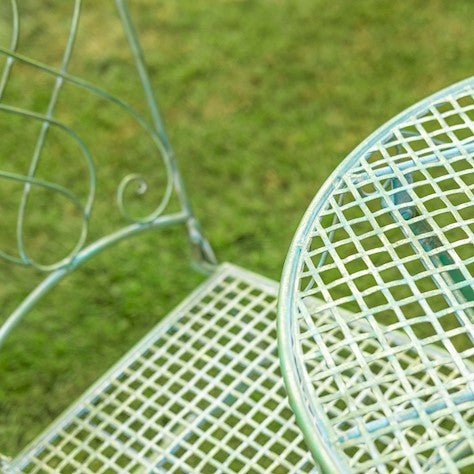 Vintage lattice-detail of Avalon Garden Bistro Set table and chair on green grass, perfect for summer outdoor dining.