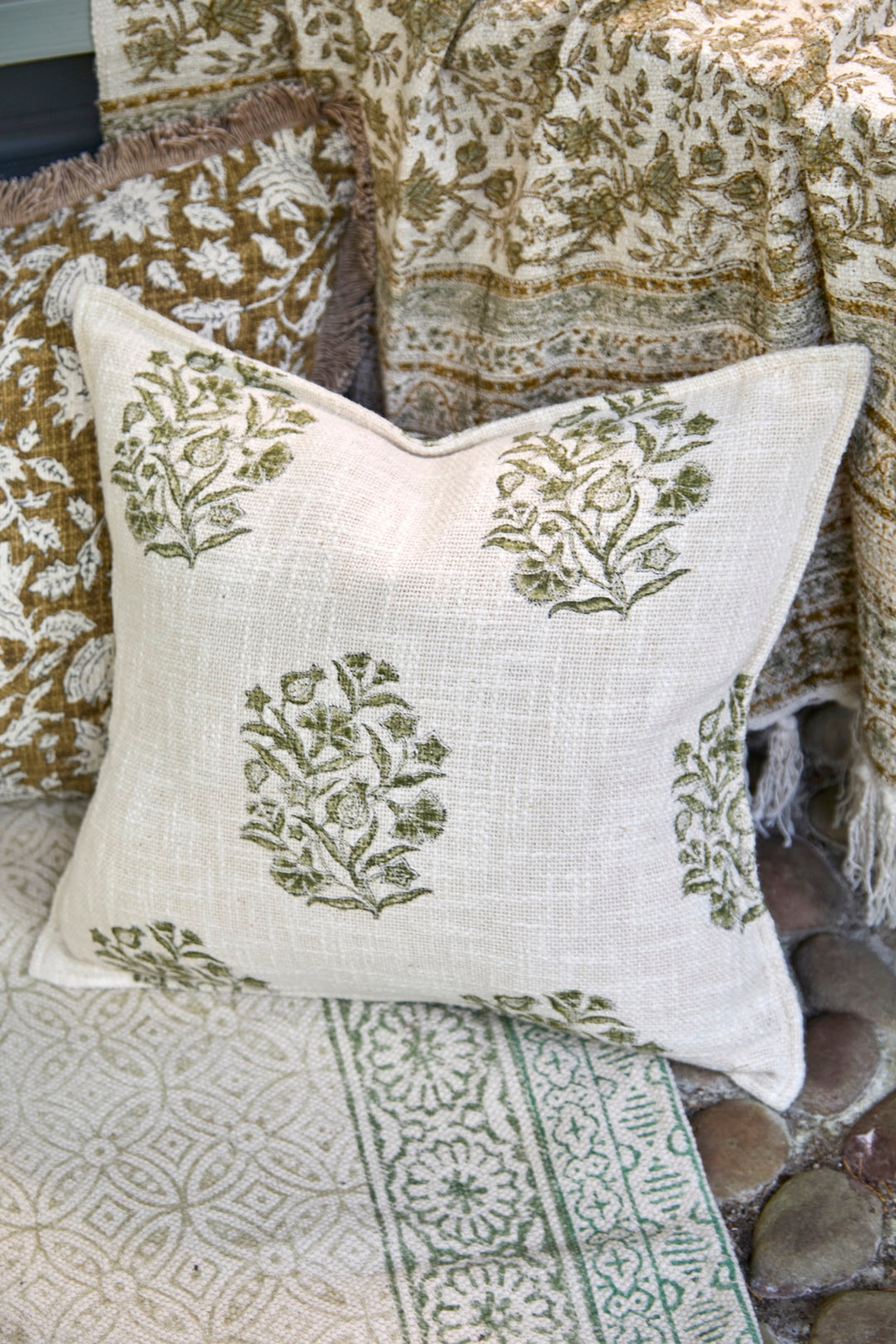Hand Block Print Cushion in Olive Green - Blickling on a cozy surface, showcasing artisan charm and unique design.
