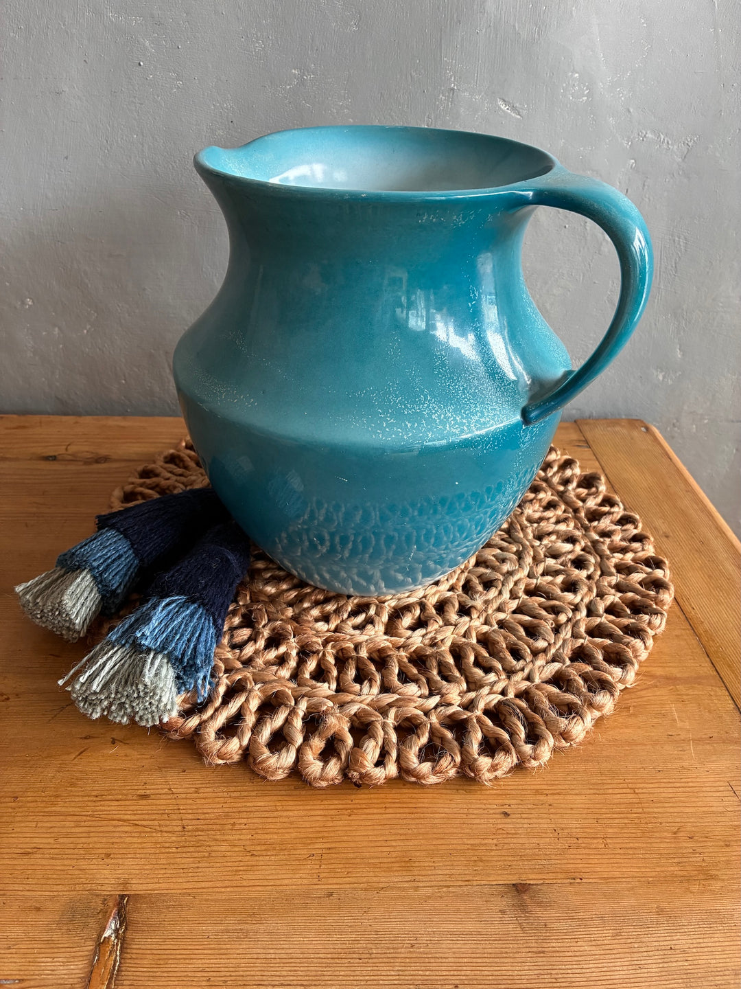 Beautiful blue Victorian water jug on a woven placemat, perfect for adding charm to any decor. Source for the Goose, Devon.