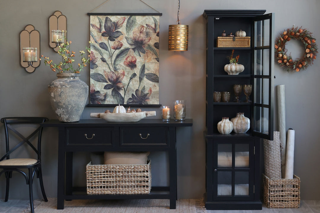 Stylish living room display with black console table, floral wall art, and decorative storage cabinet.