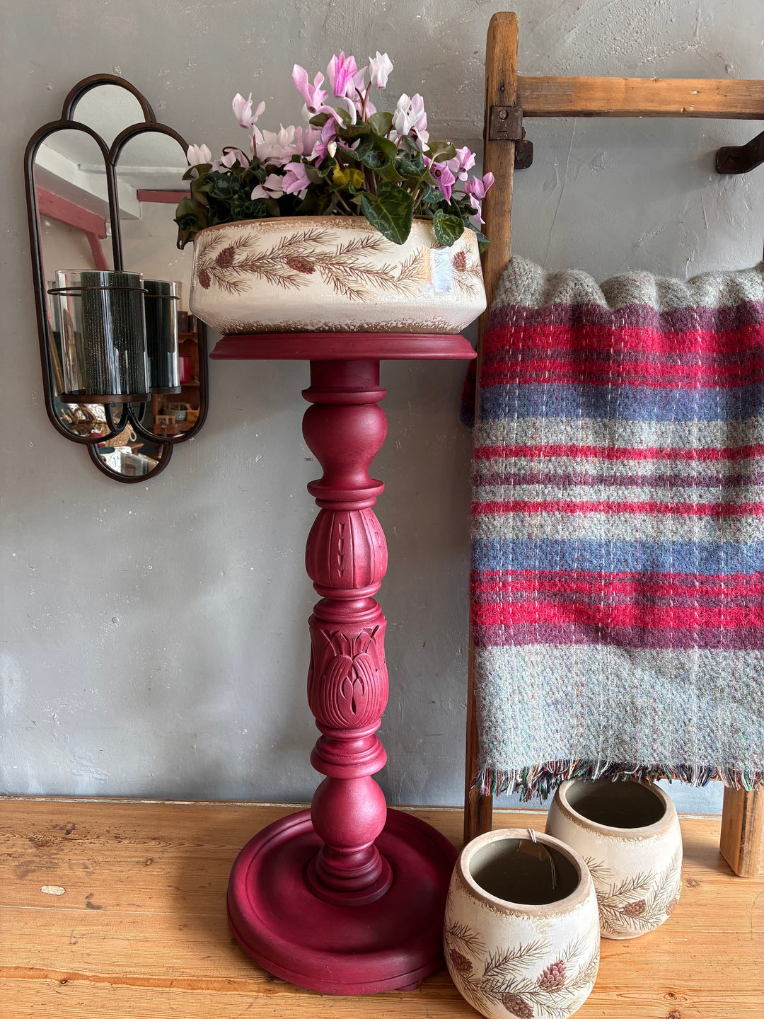 Vintage Wooden Burgundy Plant Stand with flowers, decorative items, and cozy throw blanket.