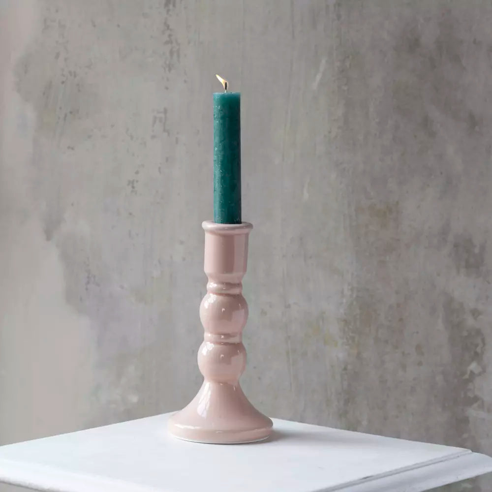 Blush Pink Crackled Glaze Candle Holder with teal candle on white table surface.
