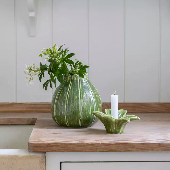 Charming Green Candle Holder and Vase Duo with flowers and a candle on a wooden countertop by Source for the Goose Devon.