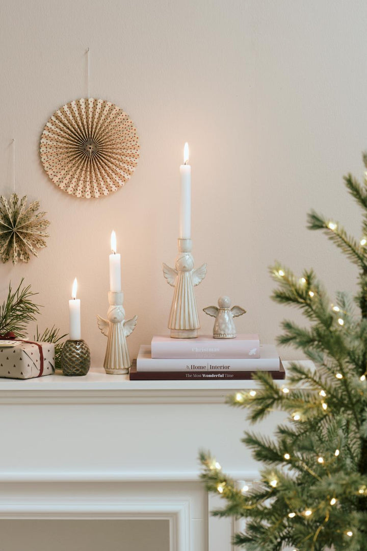 Festive Ceramic Angel Candleholders on a mantel with candles, rustic decor, and a Christmas tree by Source for the Goose, Devon.