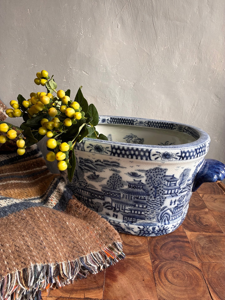 Chinoiserie Blue and White Foot Bath Planter with flowers and textiles, showcasing elegant decorative style.