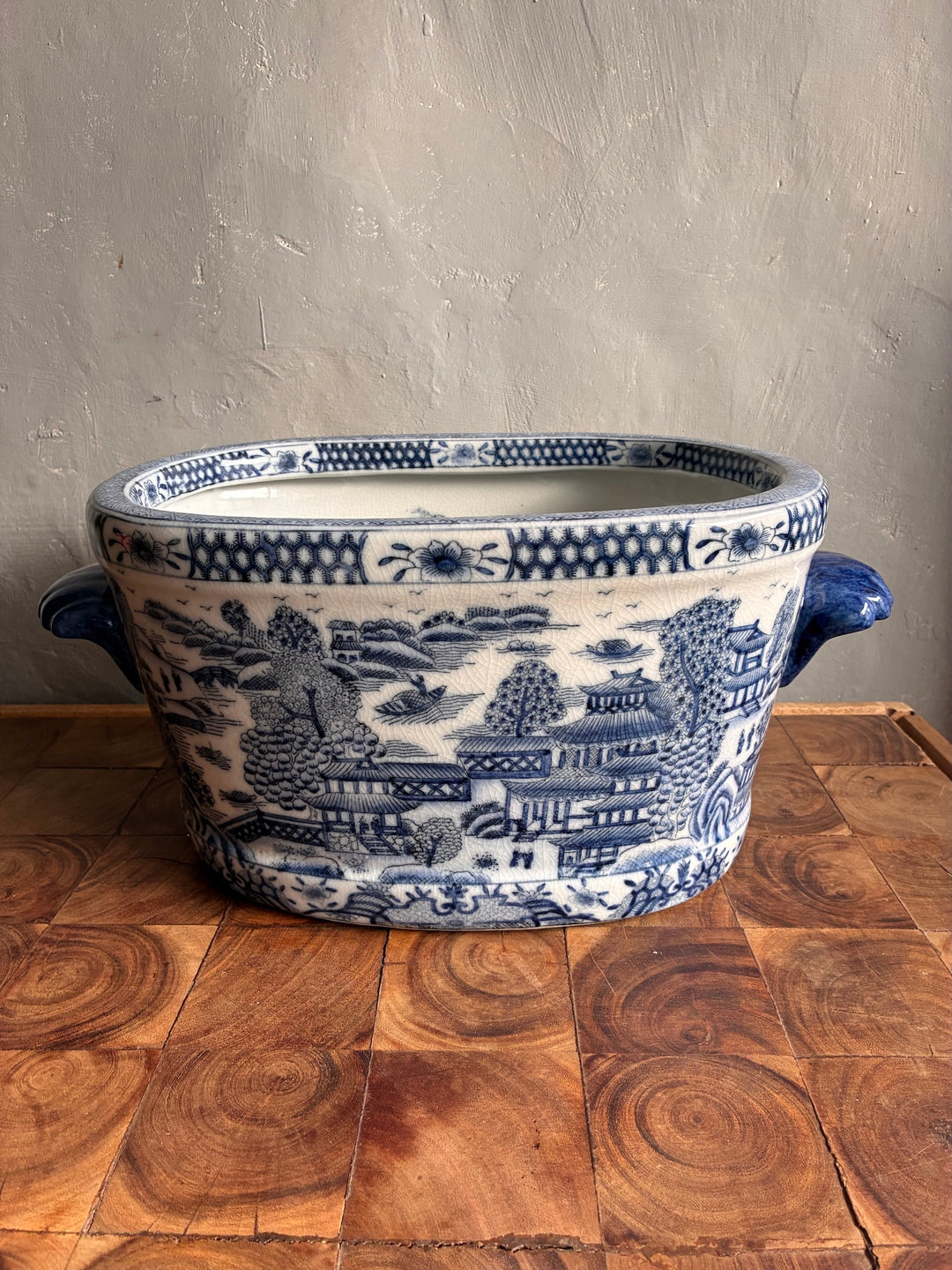 Chinoiserie Blue and White Foot Bath Planter with delicate landscapes and floral designs on a wooden surface.