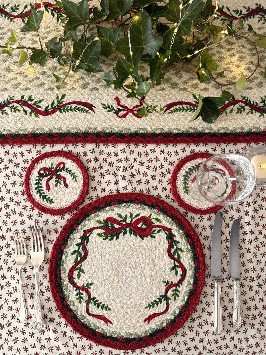 Christmas Ribbon Jute Table Runner- Christmas Tableware with festive greenery and red accents on a stylish table setting.