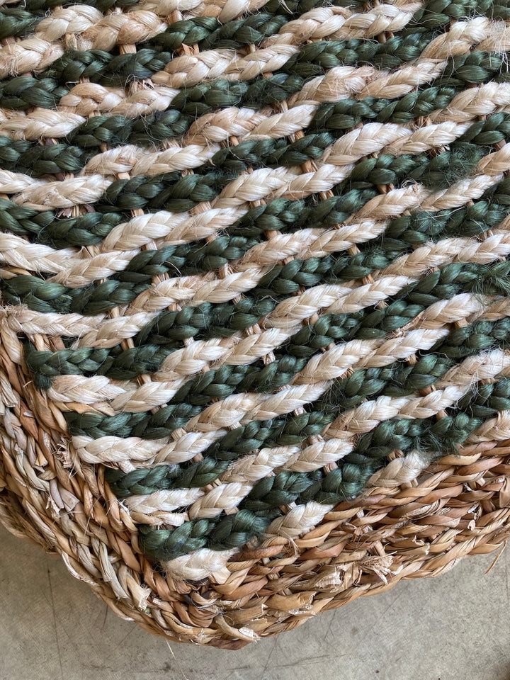 Close-up of a stylish jute mat in green and natural tones, showcasing a woven pattern, perfect for eco-friendly decor.