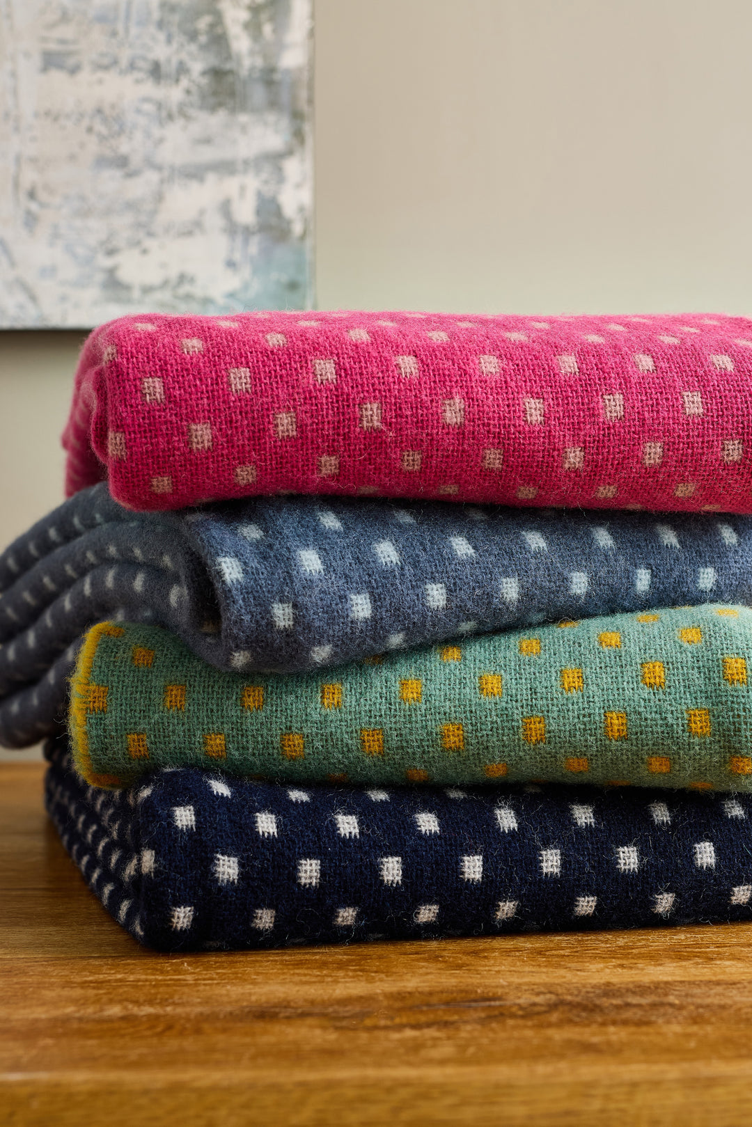 Tweedmill Navy Dot Wool Throw among colorful wool throws in pink, blue, green, and navy with polka dots.