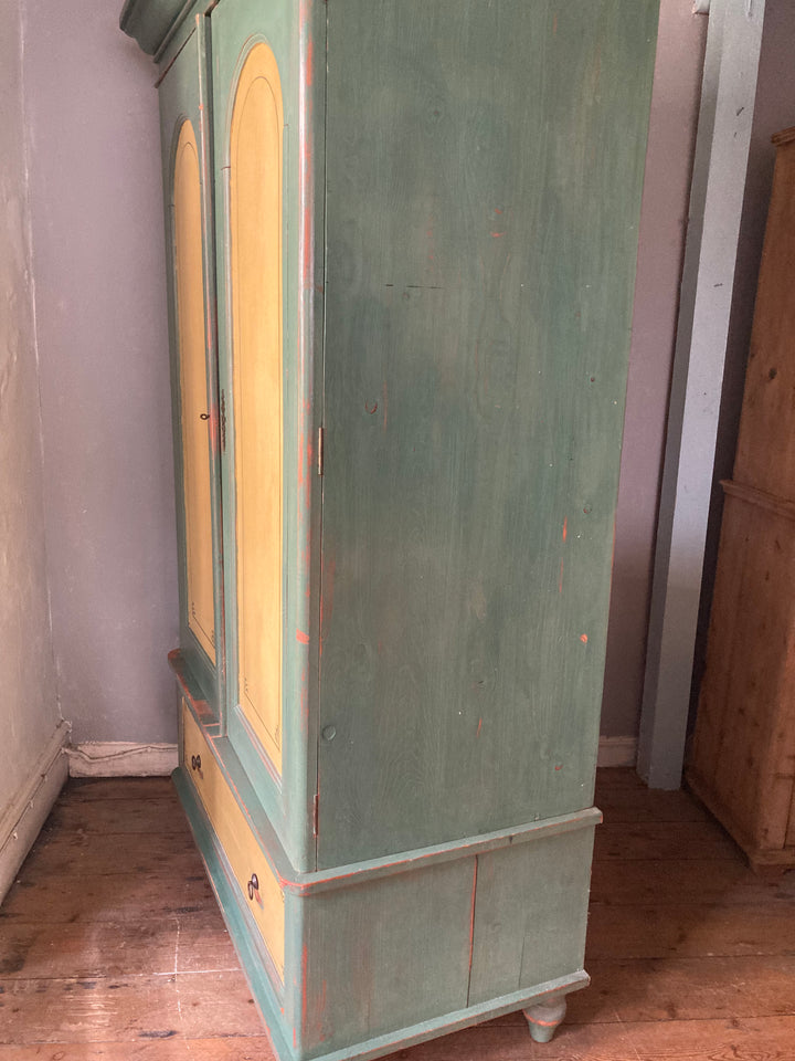 exterior side view of green and yellow painted double wardrobe