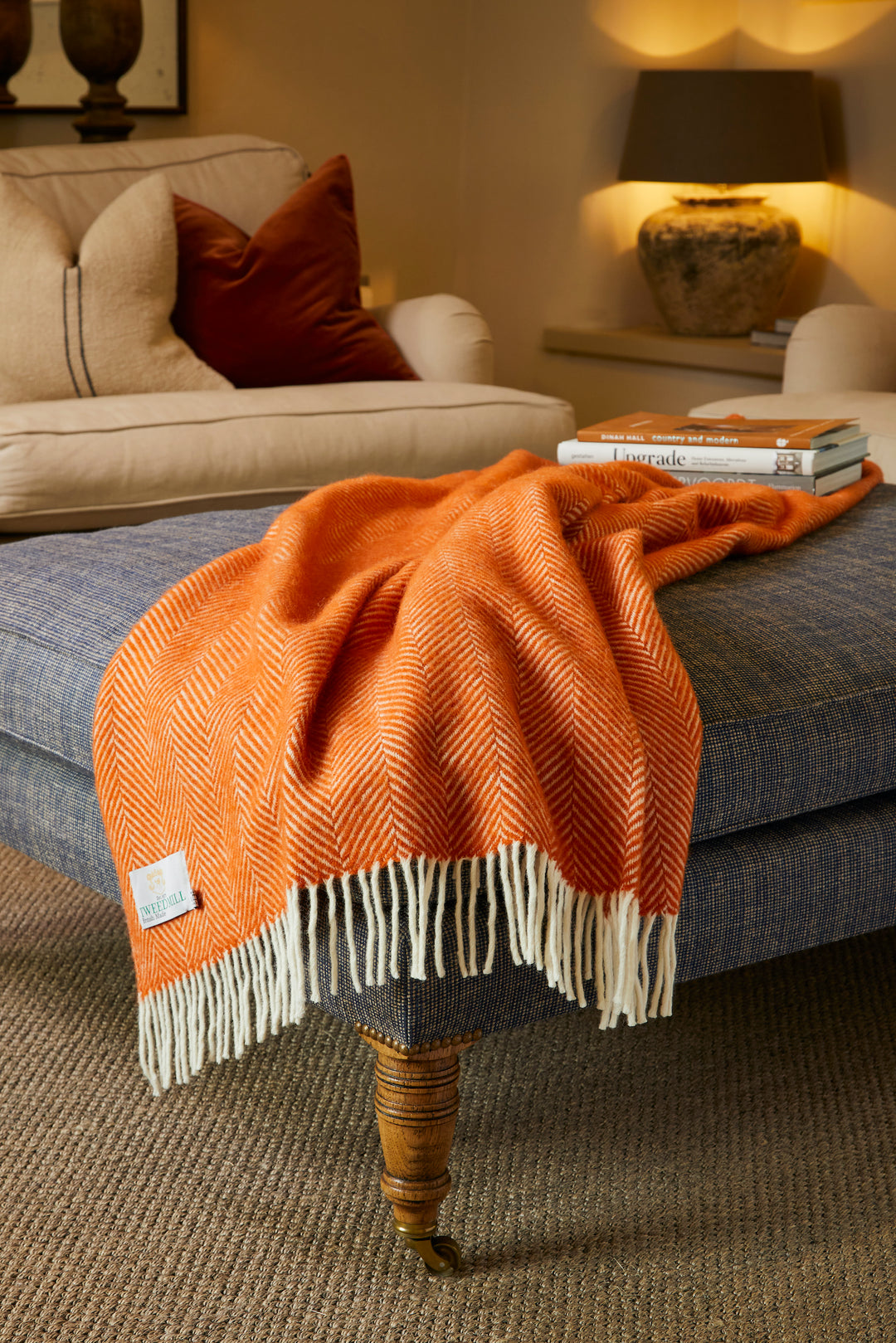 Tweedmill Fishbone Cinnamon Wool Blanket draped over a  stool