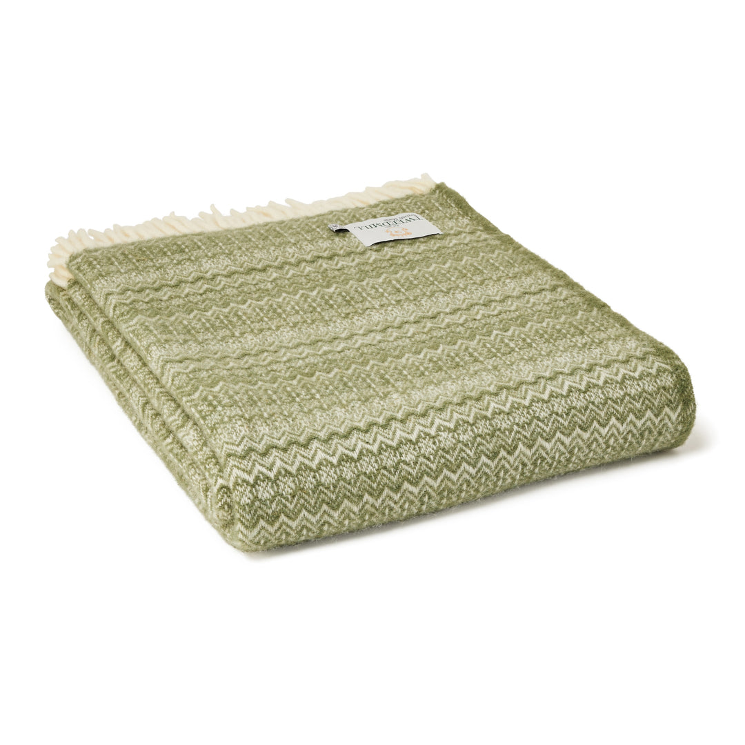 Tweedmill Sage Green Fair Isle Wool Throw folded with cream fringe, perfect for cozying up or outdoor use.