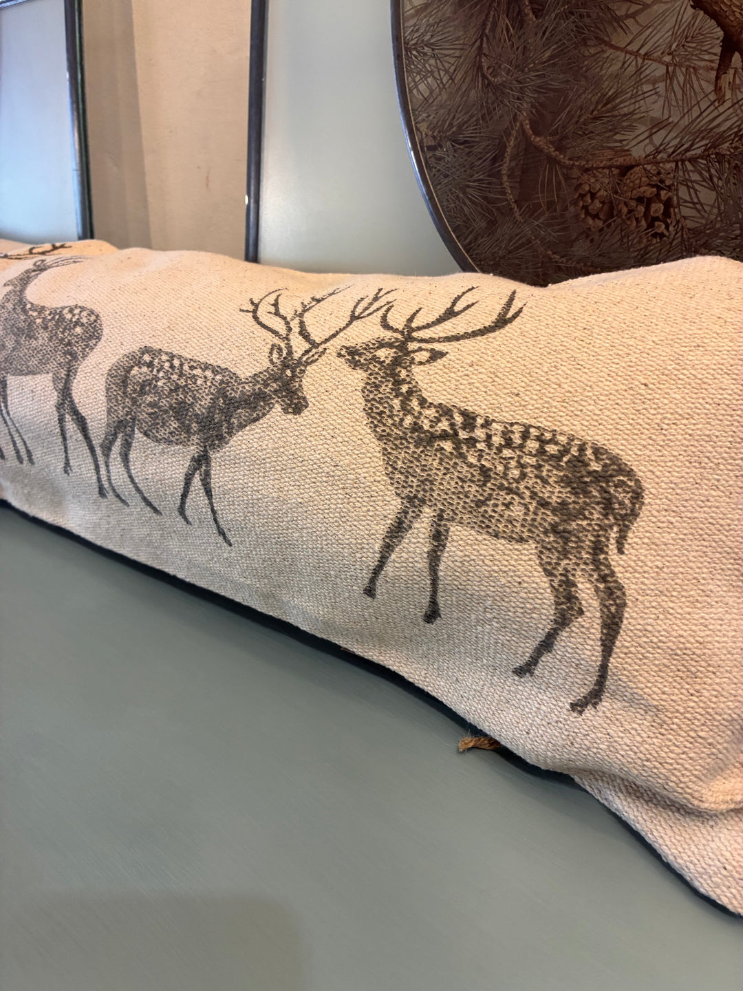 Forest Stag Draught Excluder Cushion with rustic stag silhouettes on a textured fabric, perfect for rustic home decor.