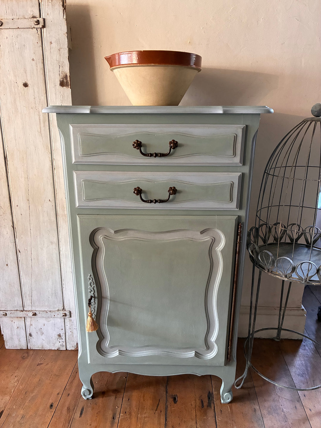 French Confiturier Cabinet in Eau De Nil Green with brown bowl on top in rustic setting.