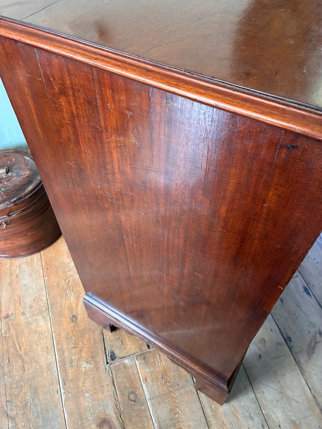 Antique Georgian mahogany chest of drawers showcasing rich wood grain and elegant bracket feet, perfect for storage.