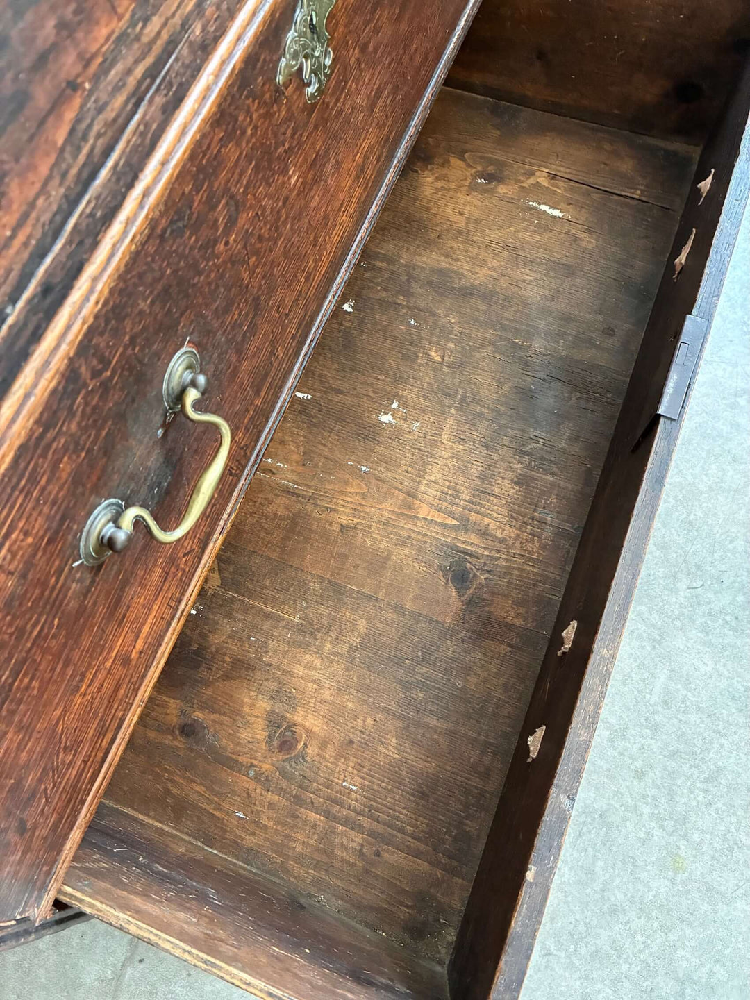 Inside view of the Antique Oak Georgian Chest of Drawers showcasing spacious storage and traditional brass handles.