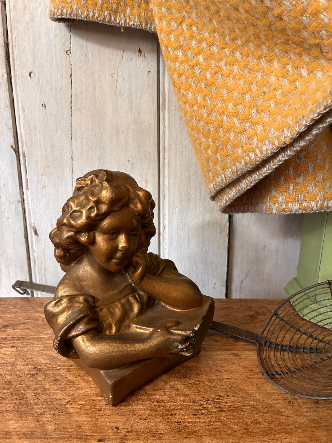 Antique Gilded Plaster Bust - Girl Reading Book - The Dreamer elegantly displayed on a wooden surface.