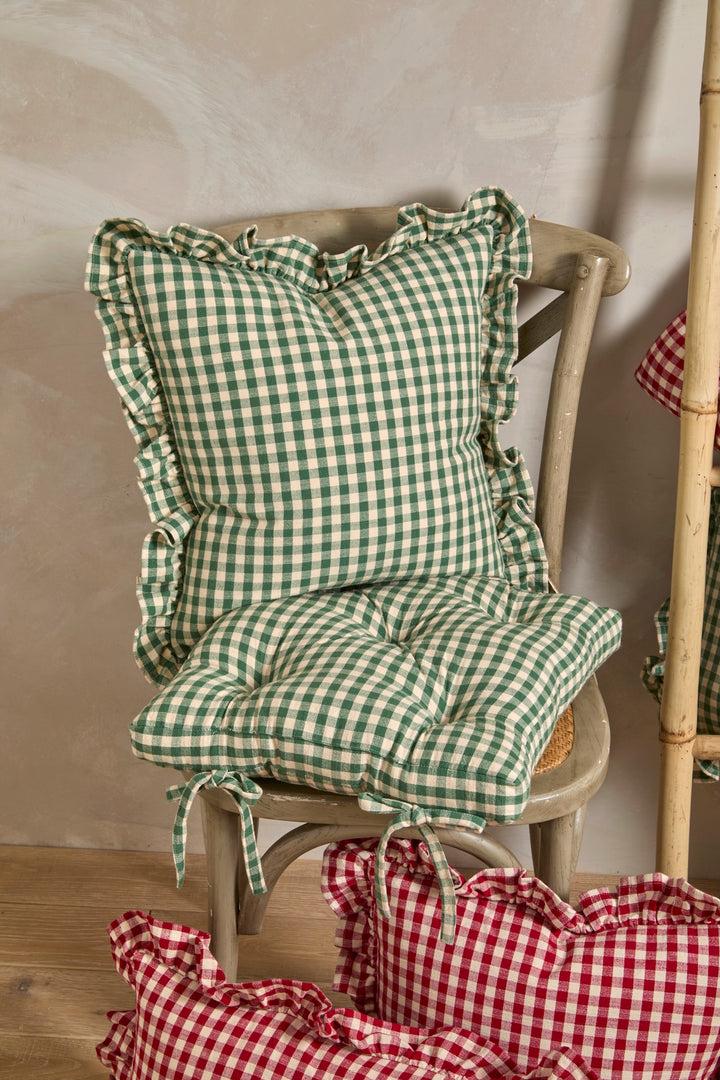 Forest Green Gingham Cushion on rustic chair with cozy gingham design and frills, perfect for farmhouse kitchen decor.