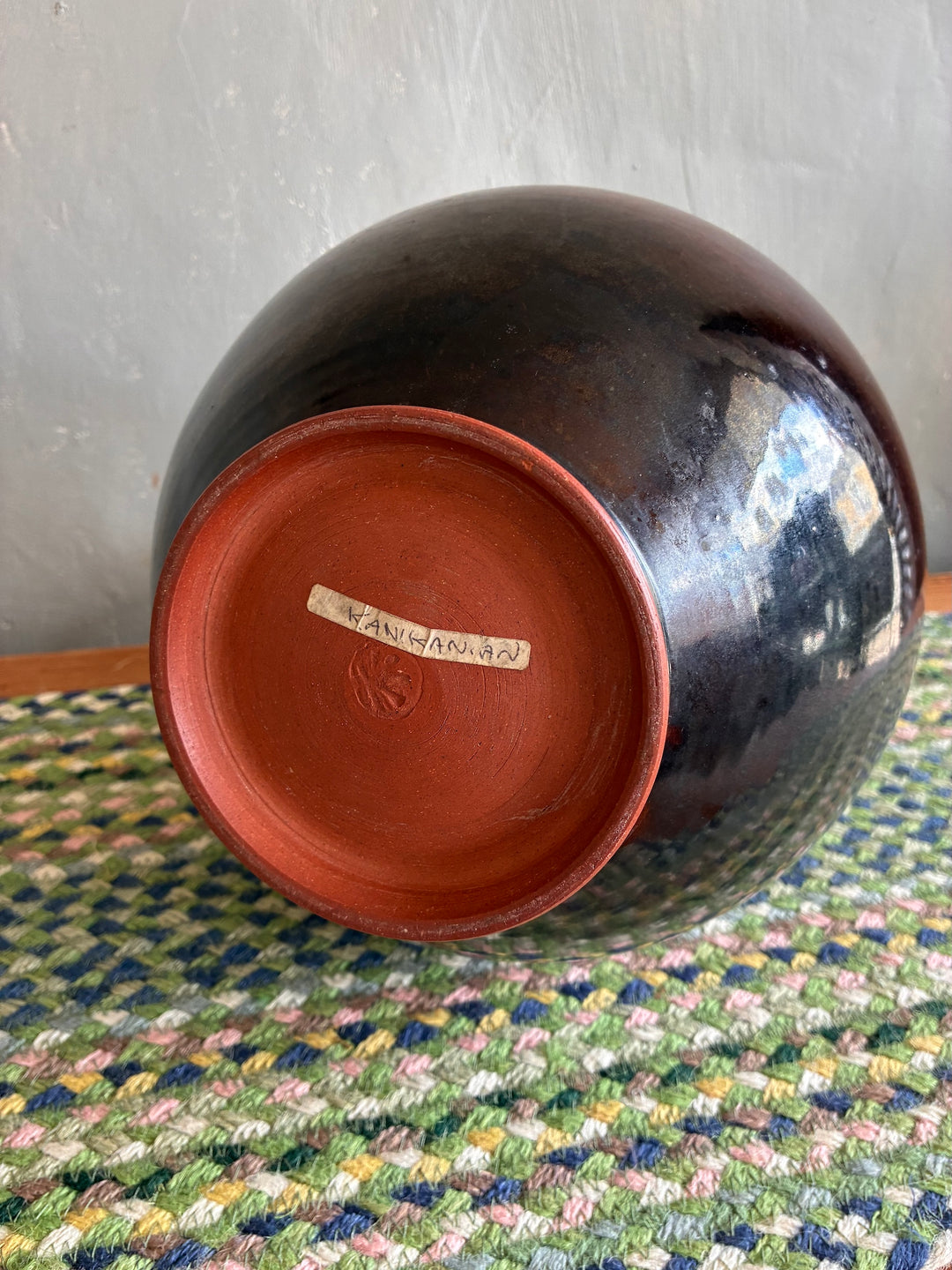 Bottom view of a glazed studio pottery vase by Vresh Kanikanian, showcasing unique glaze and craftsmanship.