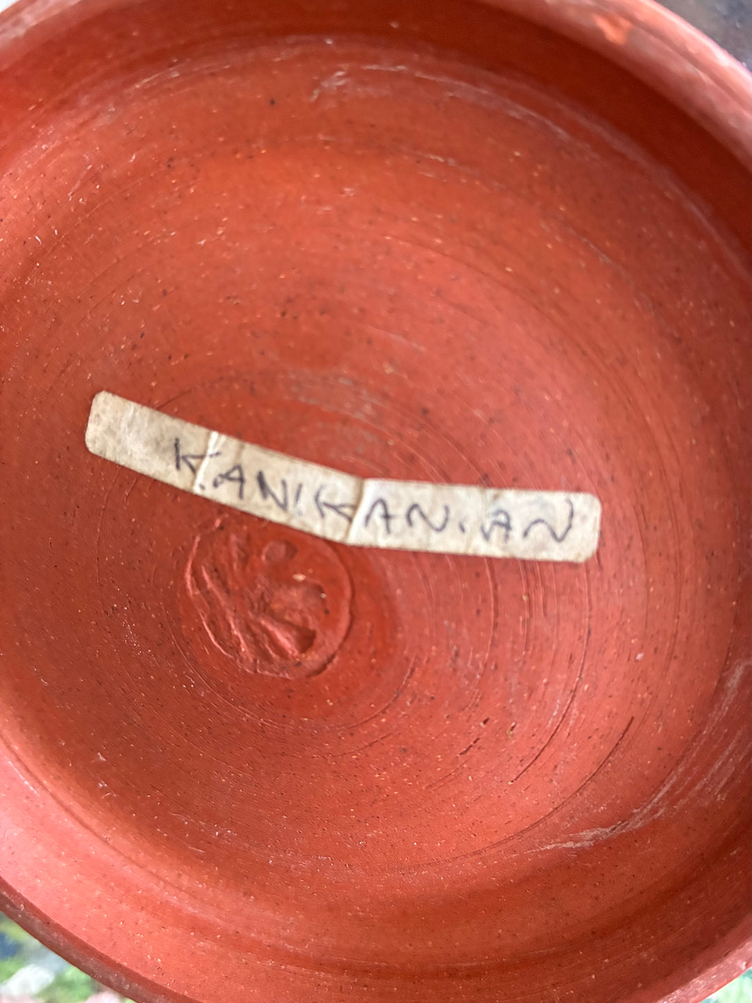 Base of studio pottery vase showing the artist's signature Kanikanian on a label.