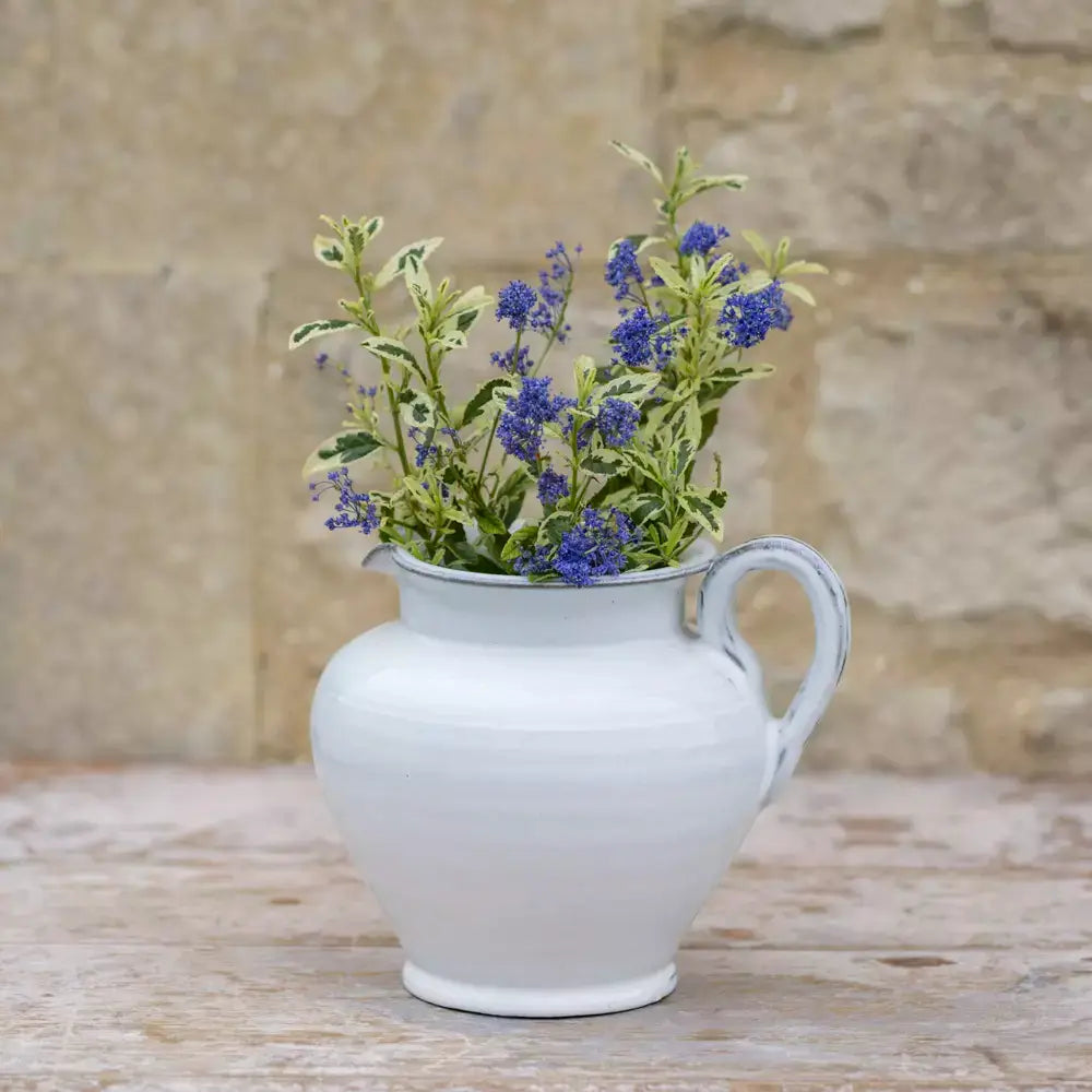Short glazed white ceramic jug with wildflowers, perfect for vintage style and rustic home decor