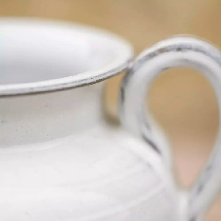 Close-up of a handmade ceramic jug with a flawless white glaze, showcasing its vintage style and rustic home appeal.