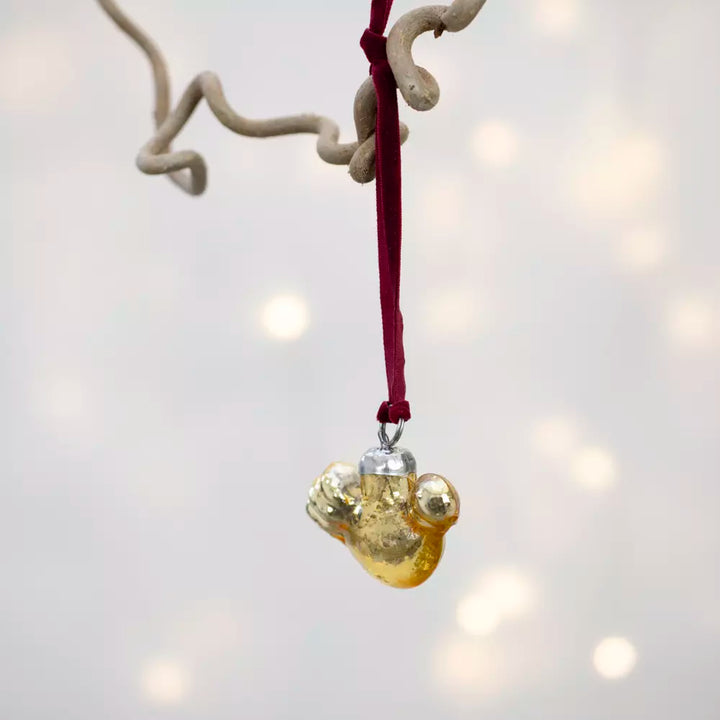 Gold Glass Bird Decoration With Velvet Loop hanging with a rich red velvet loop on a Christmas tree.