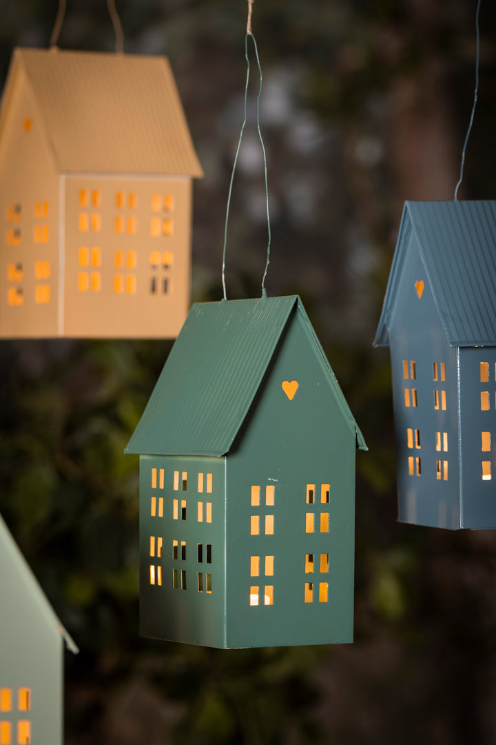 Charming green hanging candle house with cutout windows, perfect for creating a cozy atmosphere indoors or outdoors.