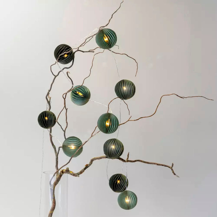 Green Pleated Paper LED Garland displayed on a branch with warm lights and eco-friendly design from Source for the Goose Devon.
