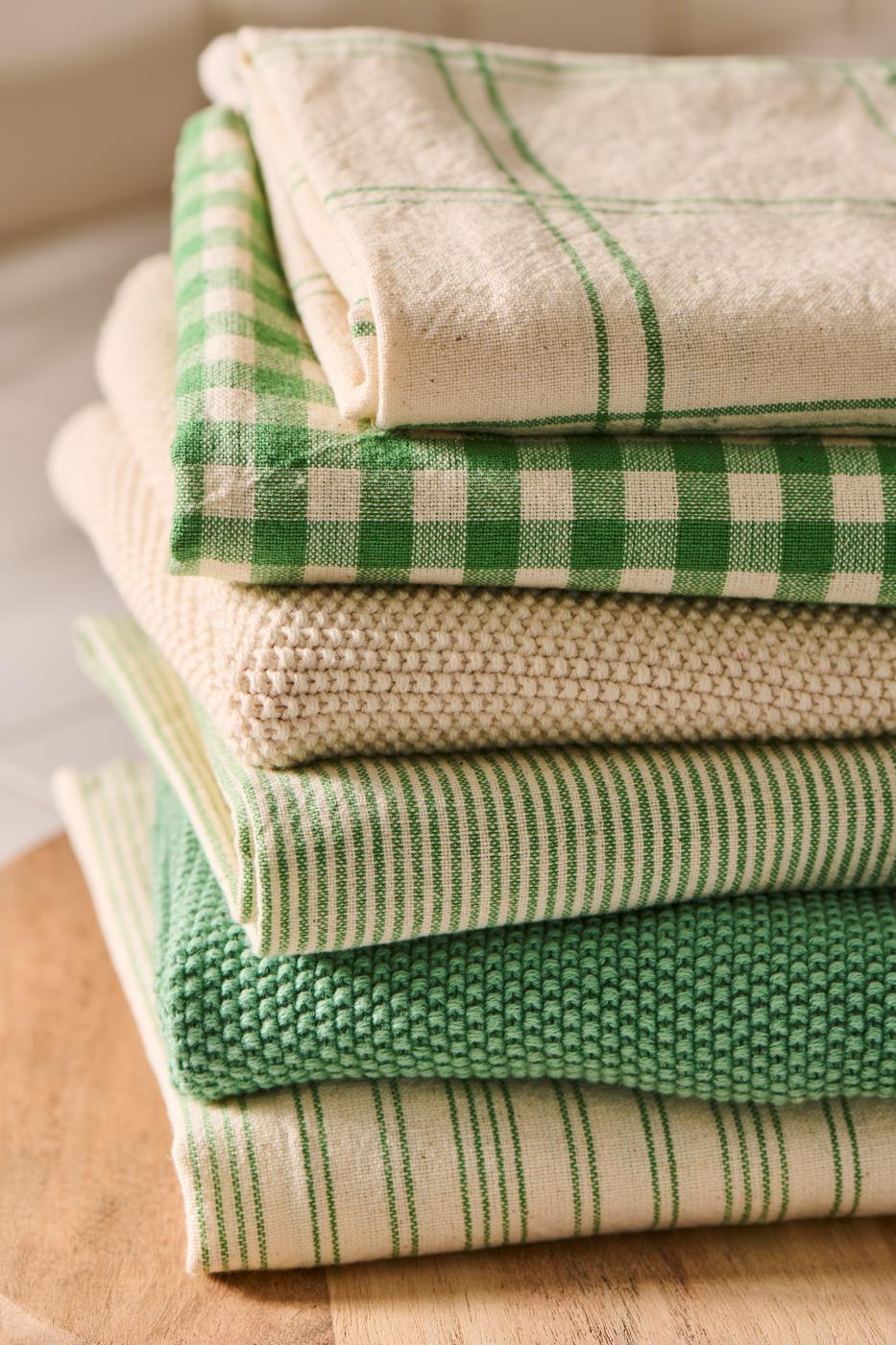 Stack of green and cream tea towels including the Green Gingham Tea Towel from Source for the Goose Devon.