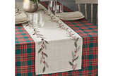 table runner with embroidered holly leaves and berries on  top of a tartan tablecloth