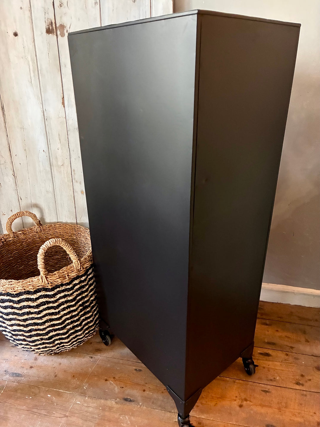 Industrial Style Metal Cabinet with Drawers in black, showcasing its sleek lines and lockable wheels for mobility.