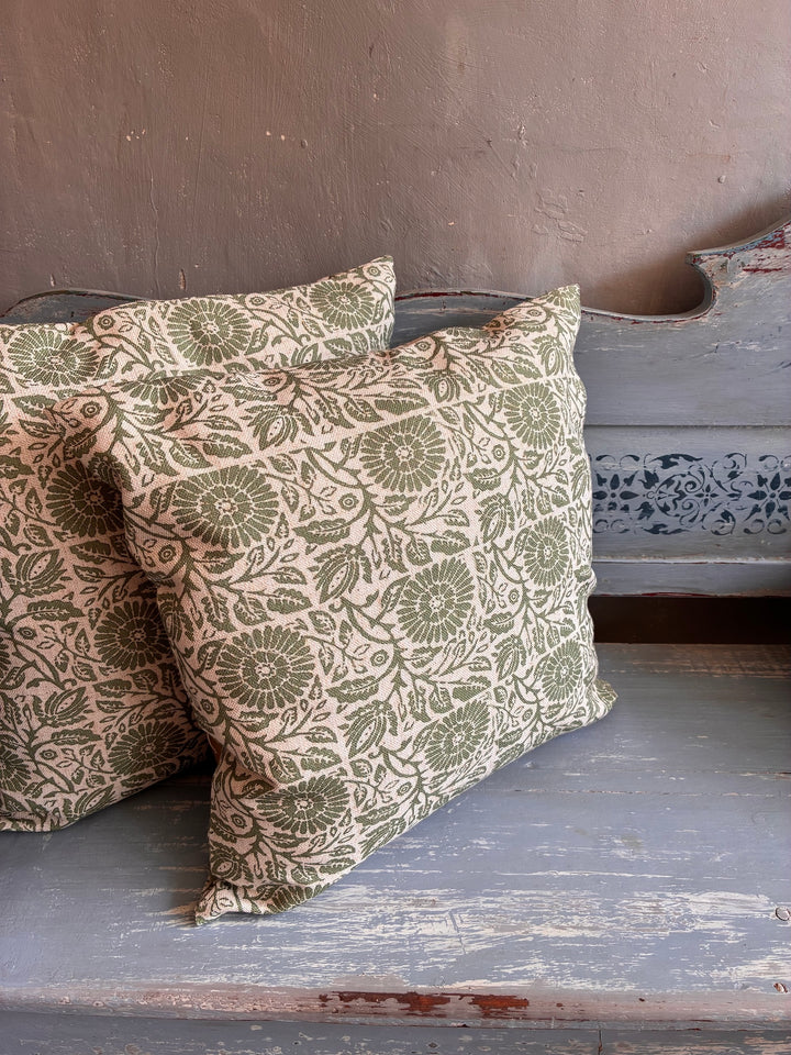 Kalla Green Hand Block Print Cushion displayed on a bench, showcasing its traditional block print design.