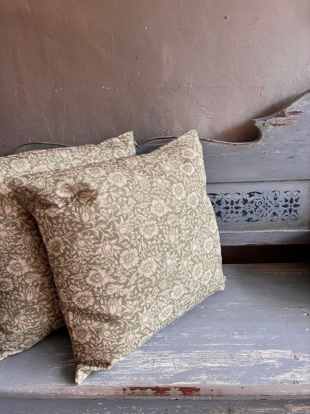 Bramble Light Corn Ochre Cushion on a rustic wooden bench, featuring floral print design.
