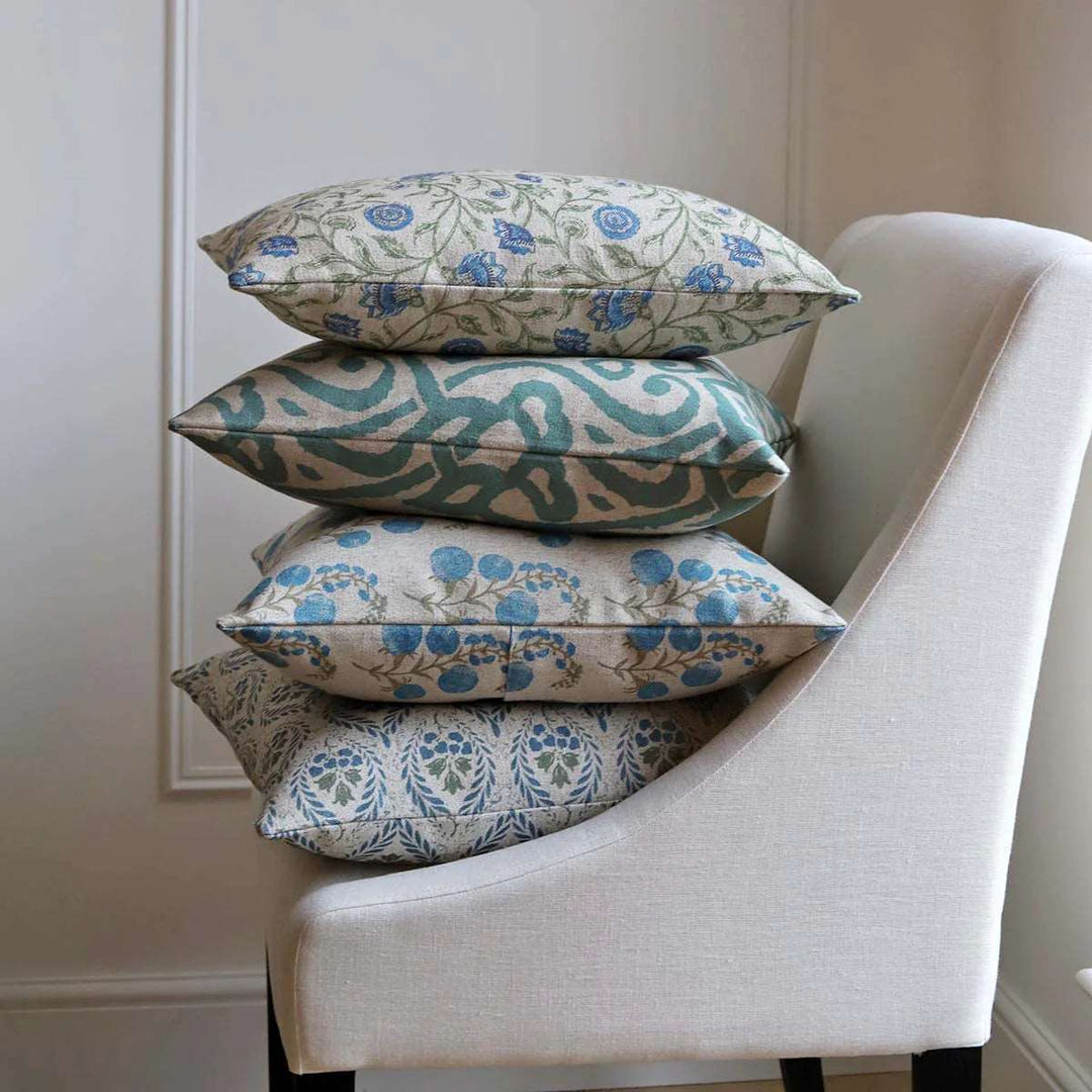 classical design cushions in blues and greens piled on a chair