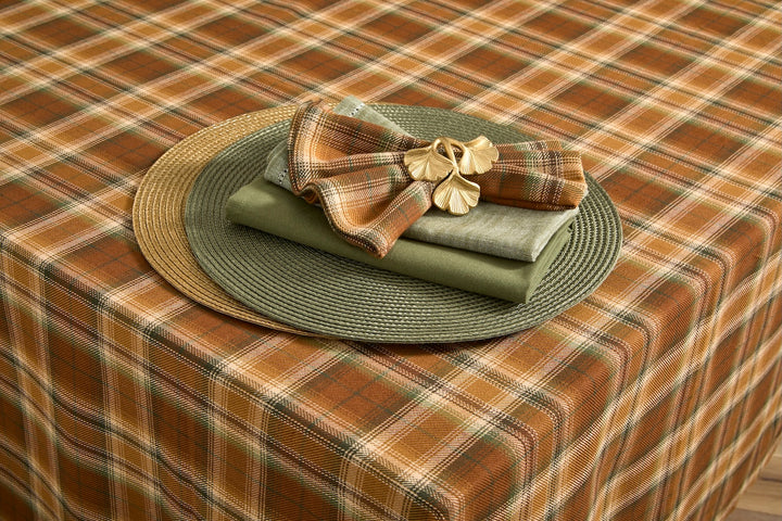 Circular Gold Placemat styled on a table with plaid tablecloth and layered napkins.