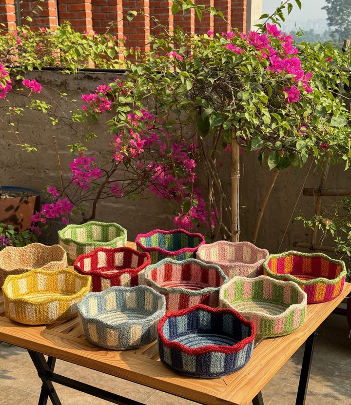 Natural Jute Stripe Tulip Mini Basket collection with vibrant colors displayed outdoors, surrounded by flowers.
