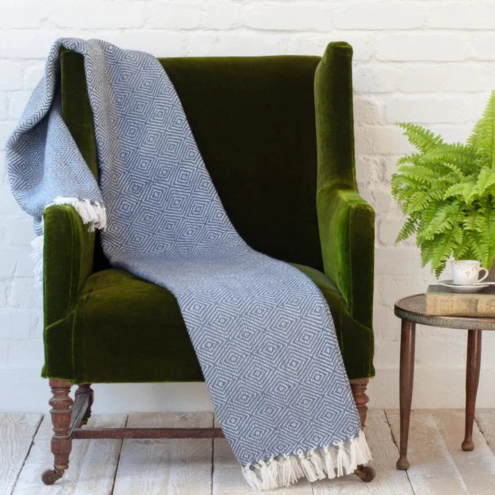 blue blanket made from recycled plastic bottles draped over a green chair