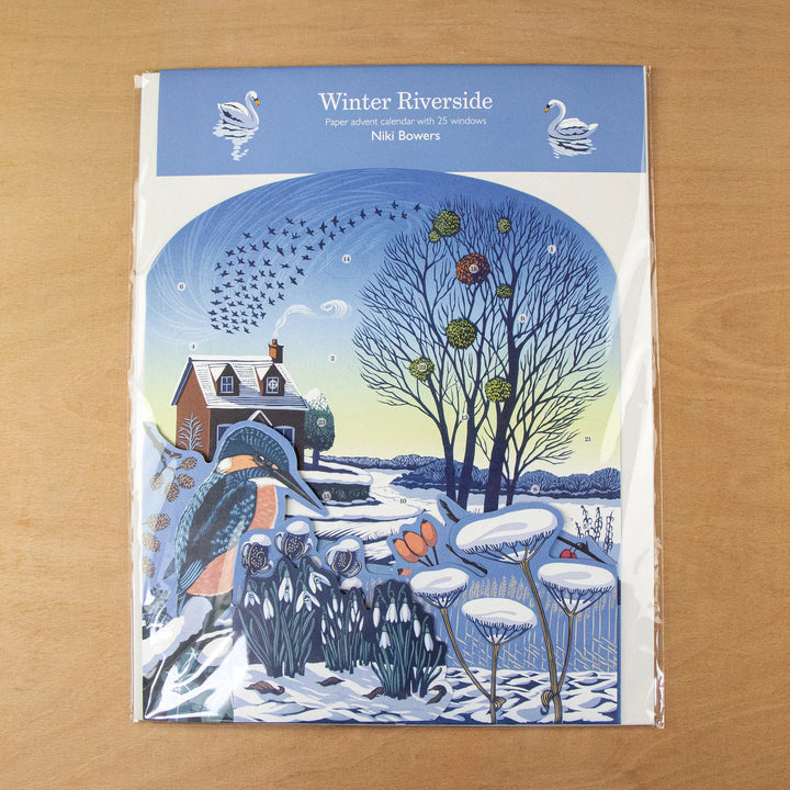 Winter Riverside Advent 2026 Calendar - Niki Bowers packaging featuring winter scene with cottage and snow.