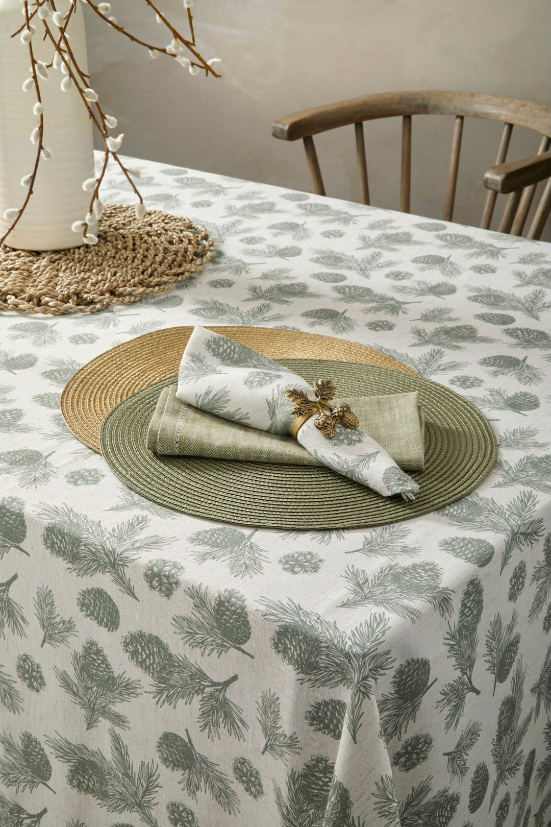 Circular Gold Placemat elegantly set with green napkins on a decorative table featuring pinecone-patterned linen.
