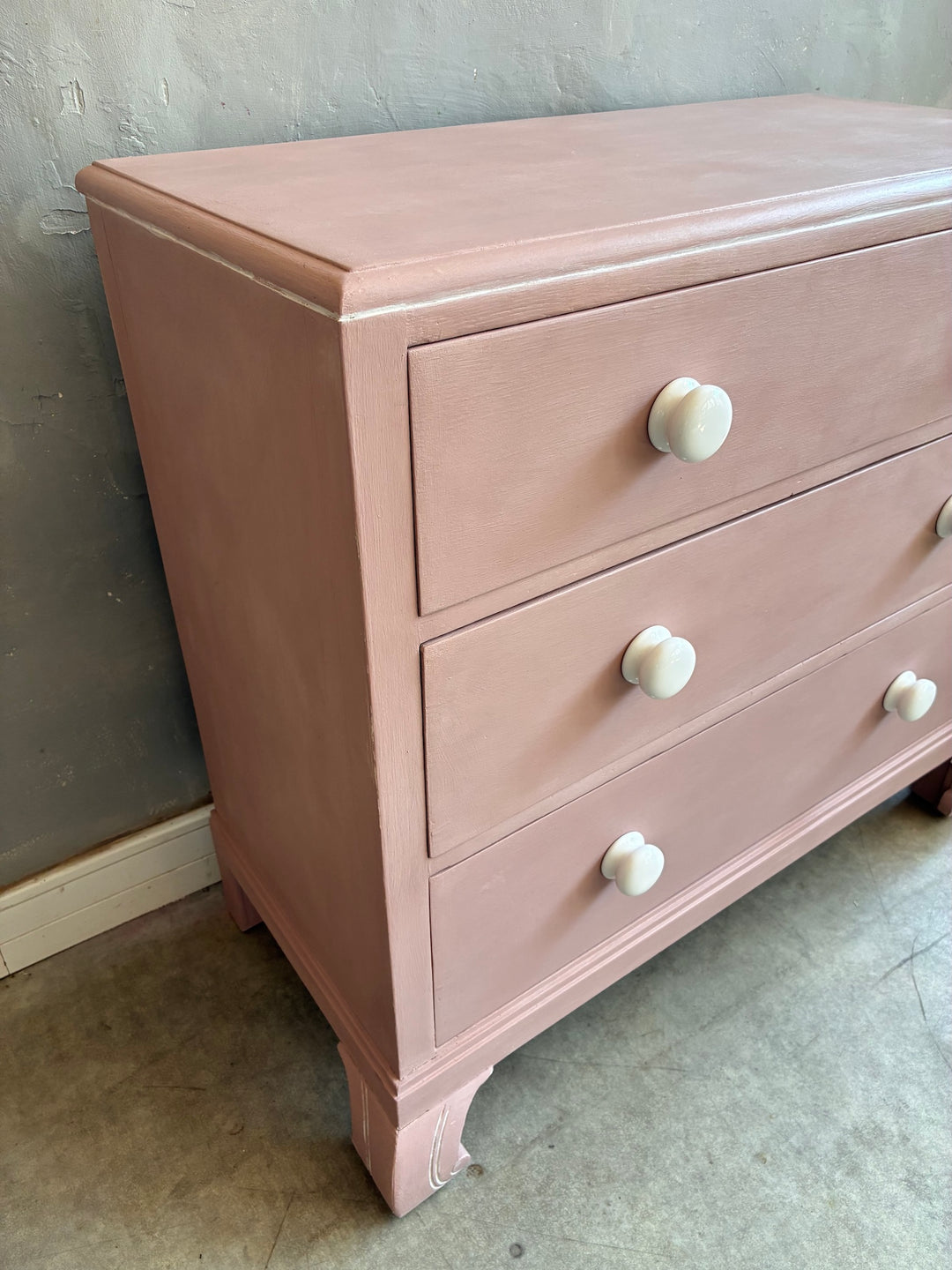 Pink Chest of Drawers with Porcelain Handles showcasing three graduated drawers and porcelain knobs.