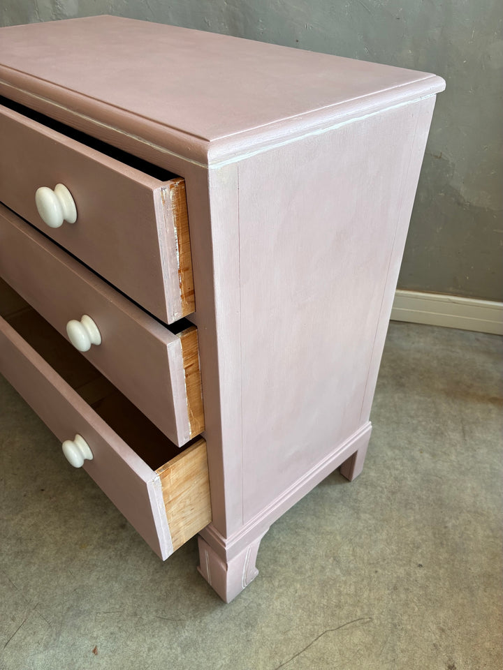 Pink Chest of Drawers with Porcelain Handles featuring three graduated drawers and porcelain knobs.