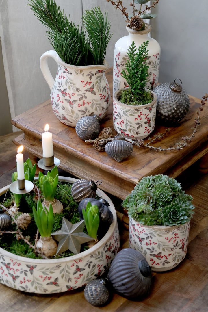 Festive Holly and Berry Decorative Planters with greenery and candles on a rustic wooden table by Source for the Goose, Devon.